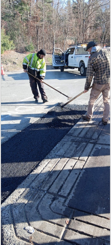 Two asphalt paving contractors paving a road
