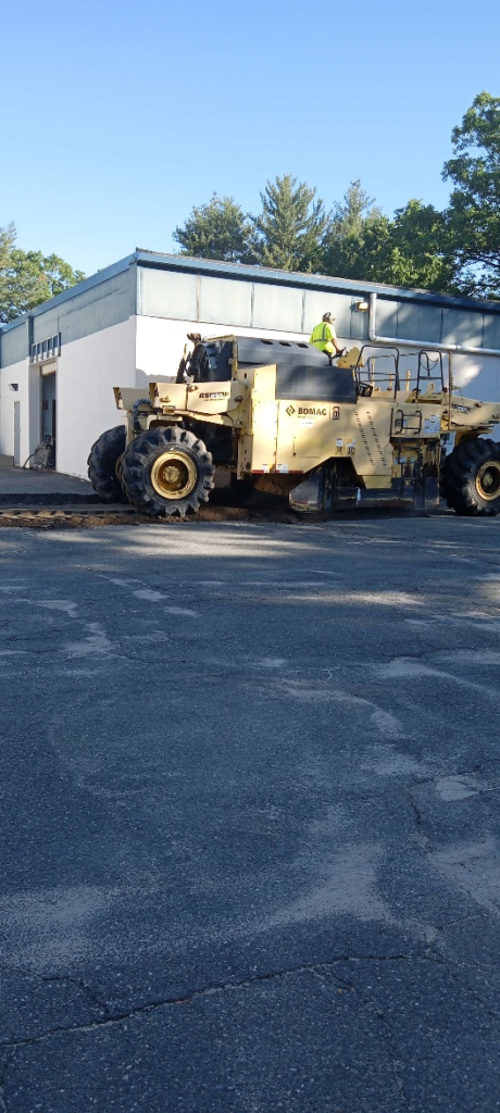A paving contractor using tractor to pave a driveway