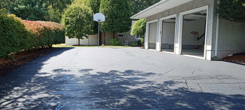 an asphalt driveway with three garages