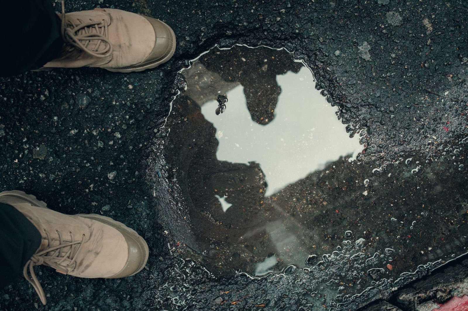 A person standing by a pothole